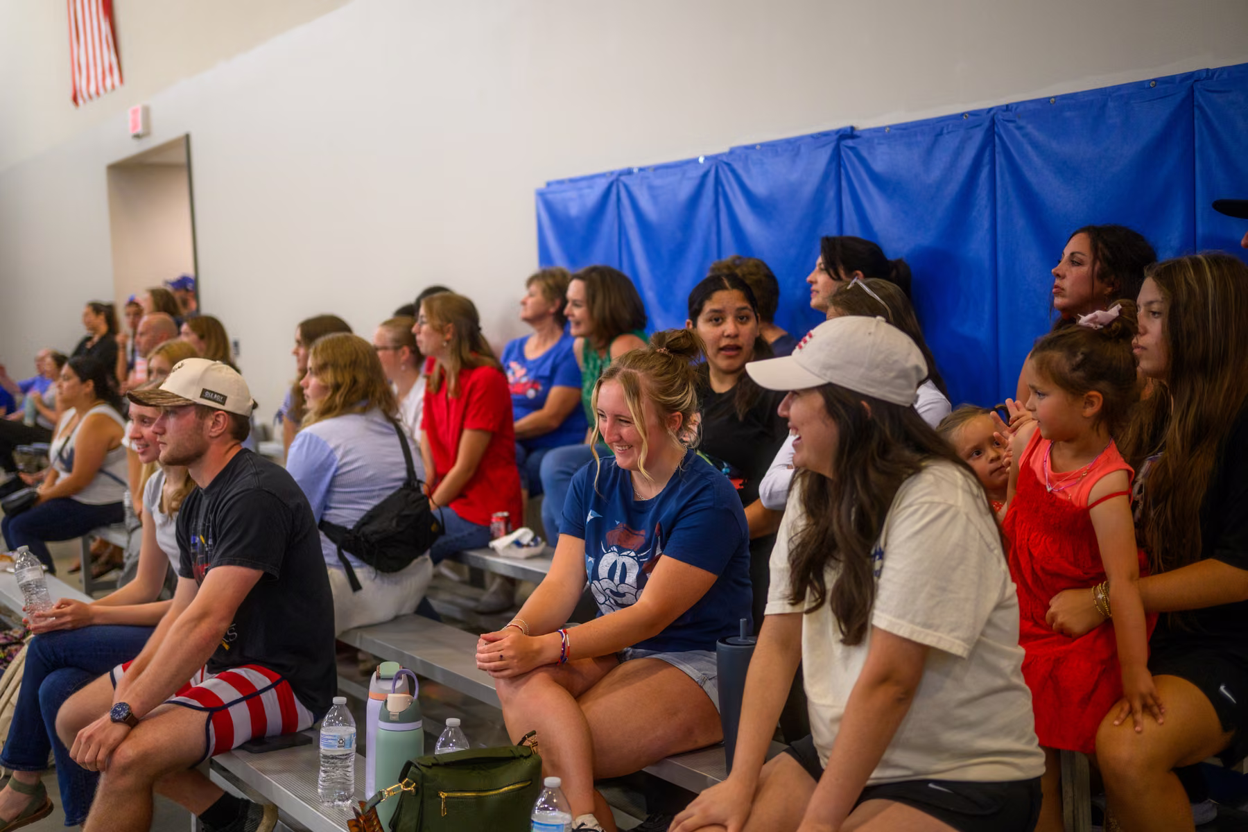 Guests seated along the edge of the gym watching the games.