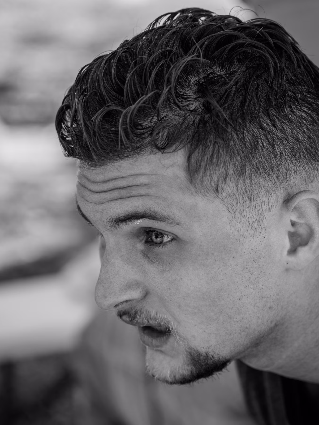 Close black-and-white portrait of Noah looking to the side after his run.